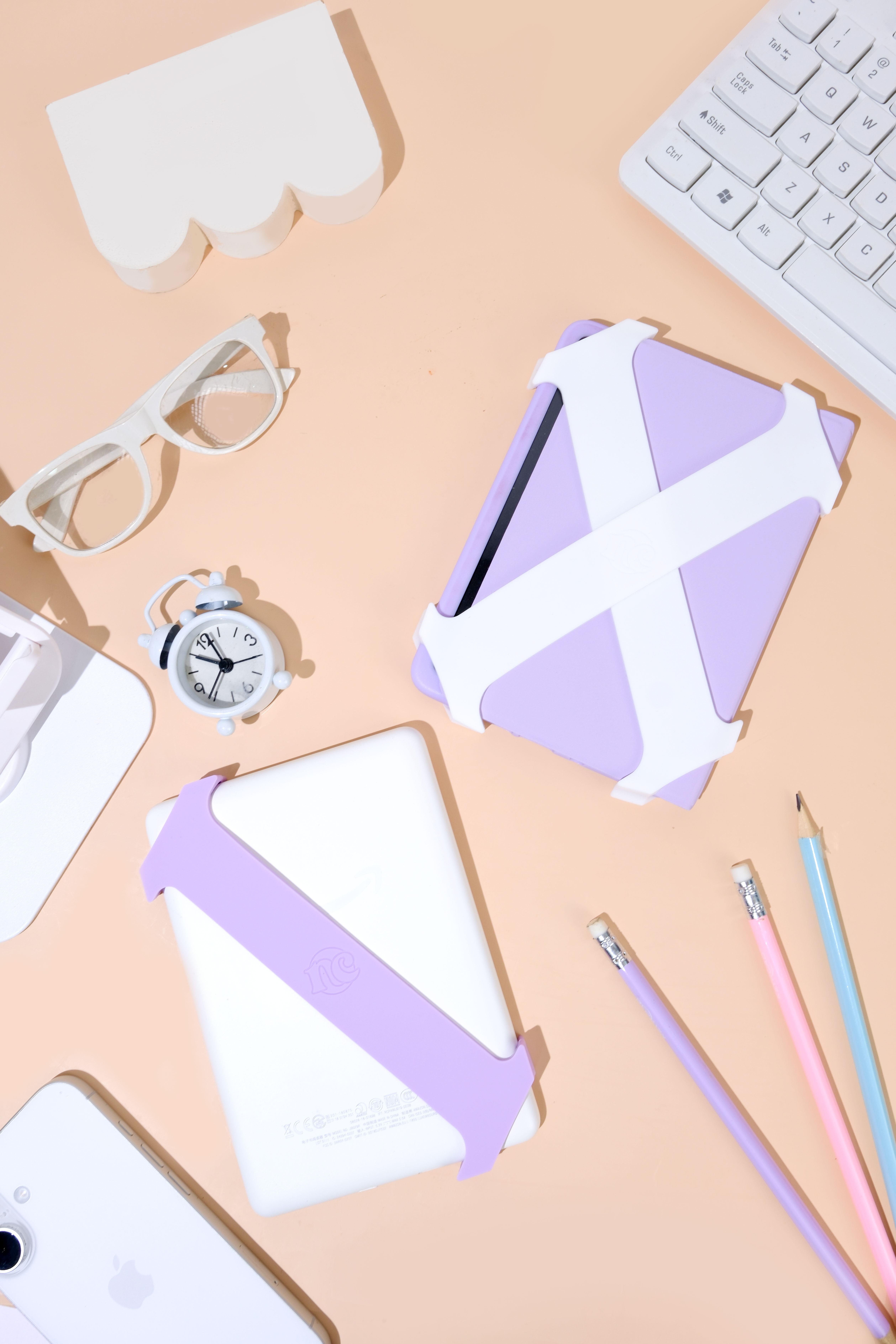 Lilac and white Everstraps beside reading and desk essentials